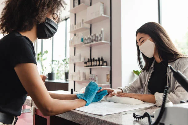 manicurista trabajando y usando tapabocas